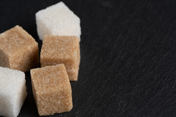 Various types sugar on dark stone background.