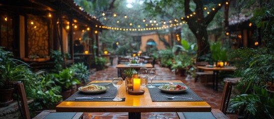 Romantic outdoor restaurant dinner setting with string lights.