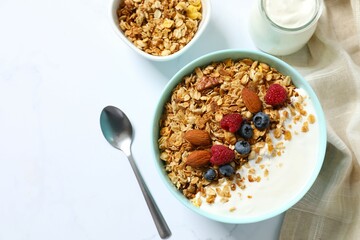 Delicious granola with berries and yogurt on a light background