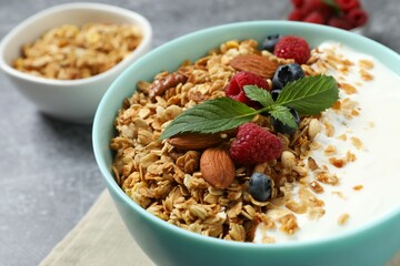 Delicious granola with berries and yogurt on a light background