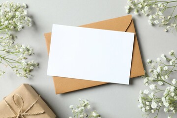 Top view photo with paper card and gypsophila flowers on gray background 