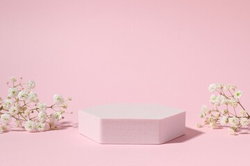 Podium and white gypsophila flowers on color background