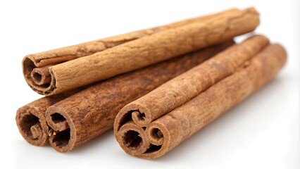 A close-up of several cinnamon sticks arranged on a white surface. The sticks are a rich brown color with visible layers and a warm, inviting texture. 