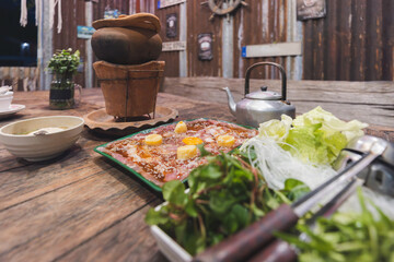 Thai hot pot food call Jim Jum with pork soup sauce and vegetable ingredient on table in Thailand