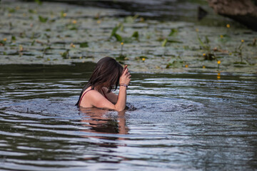 A beautiful young girl is swimming in the water.