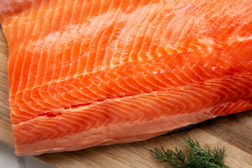 Organic Raw Salmon Fillet on a wooden board, top view. Flat lay, overhead, from above. Close-up.