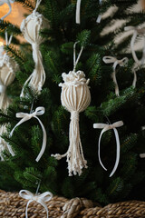 White knitted toy on the branches of a christmas tree.