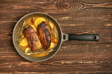 Savory roasted duck breasts with herbs and citrus in a frying pan