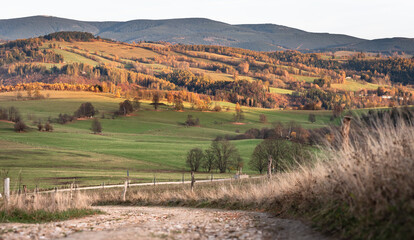 Czech Republic, Stribrnice, mountain landscape view from hiking trail, gravel road. Autumn panorama of hills and fields in late evening.