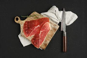 Overhead view of jamon iberico cured pork meat on a wooden cutting board, accompanied by a sharp knife