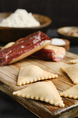 Homemade dough filled with savory ingredients ready for cooking with spices and flour in background