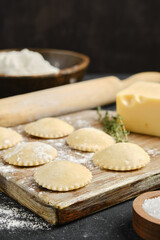 Homemade pasta preparation on a wooden surface with ingredients and tools