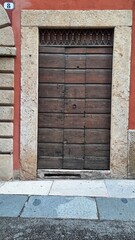 Verona, Italy, 10.05.2024, antique door made from pieces of wood