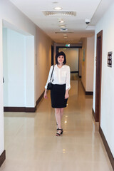 Confident Woman in a White Blouse Navigating the Halls of a Bank, Embodying Professionalism and Determination as She Moves Through Corporate Environment with Purpose and Grace.