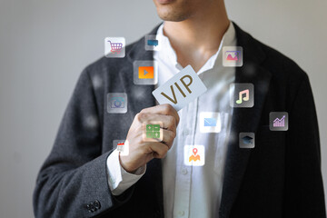 A man is holding a card that says VIP. The card is surrounded by icons of various apps