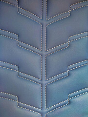 A pattern formed by the stitching design of a sofa chair.