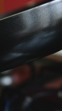 Hands of woman holding a new pan, choosing black teflon frying pan, customer deciding to buy non-stick frying pan for cooking food in her kitchen. pour in sunflower oil