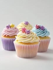 Four colorful cupcakes with swirled frosting and decorative star toppings on a light background.