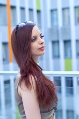 Portrait of a beautiful woman walking in the city. She is wearing a black dress and her chic hair is combed back. Leisure concept.