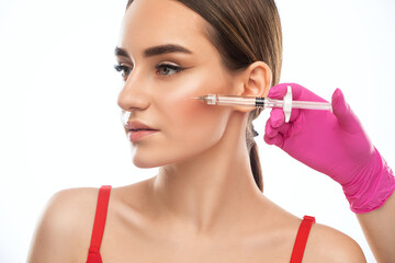 Cosmetologist does injections for lips augmentation and anti wrinkle in the nasolabial folds of a...
