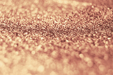 Golden defocused glitter background with bokeh effect, display concept