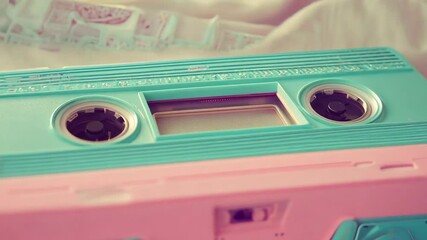 Retro cassette tape in turquoise and pink tones, nostalgic and playful, vintage vibes, capturing music memories, soft pastel colors, fun and lively. - Powered by Adobe