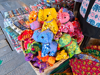 bright fabric toys of elephants for sell on street market souvenir stall. Elephant is a popular tourist design in Thailand. Selective focus