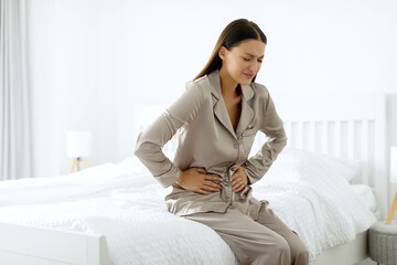 Lady feeling stomach pain in the morning, sitting on bed and touching belly, having menstruation...
