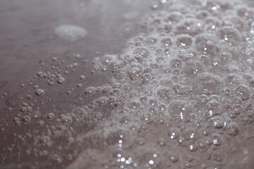 Bubbles on water with slight red tint