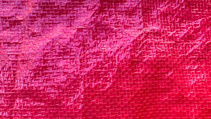 Red plastic floor, slippery and wrinkled texture, red background, abstract background.