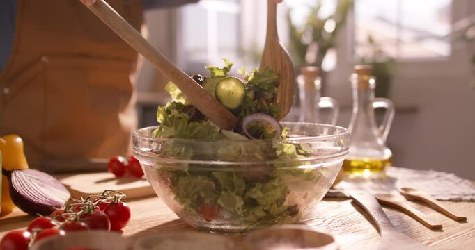 Closeup of a Fresh Mediterranean Salad Being Tossed and Mixed with Vibrant Vegetables in a Sunlit, Bright Kitchen