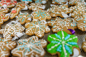 Gingerbread biscuits in the shape of snowflakes on a baking sheet. Production of New Year or Christmas cookies in a bakery. Homemade toys for the Christmas tree made of dough.
