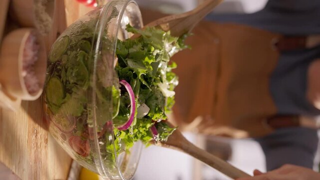Vertical Shot of Wholesome Meal Prep: Vibrant Mediterranean Salad Being Tossed with Organic Vegetables in a Bright and Inviting Kitchen