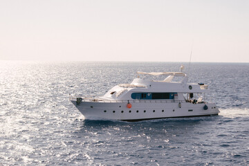 Naklejka premium A luxury private motor yacht under way on tropical sea with bow wave