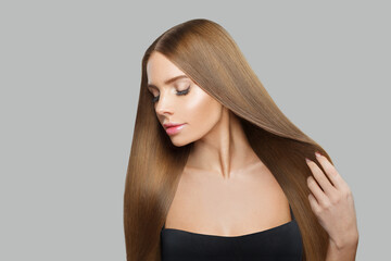Naklejka premium Glamorous female model brunette with long hair and natural make-up posing isolated on white background
