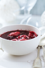 Traditional Christmas Borscht (Barszcz) with mushroom dumplings on bright background.	