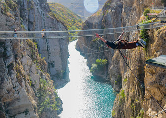 jumper was bouncing off the bungee jumping platform down towards the river in the canyon. against...