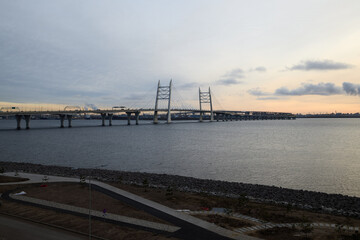 The stunning sunset view of a modern suspension bridge showcases an urban landscape at dusk