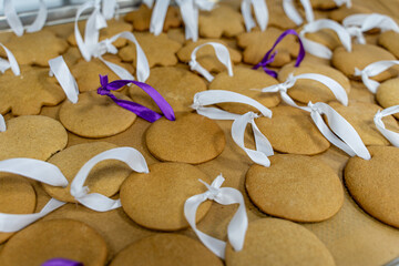 Lots of gingerbread cookies with ribbons are ready to decorate. Production of biscuits in a bakery. Background.