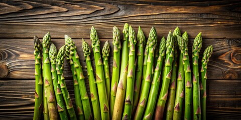 A bunch of fresh green asparagus spears arranged in a row on a wooden surface, ready to be cooked and enjoyed