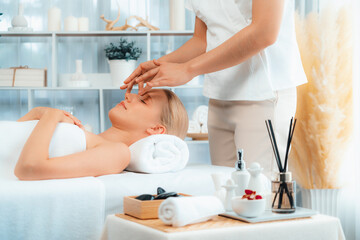 Obraz premium Caucasian woman enjoying relaxing anti-stress head massage and pampering facial beauty skin recreation leisure in dayspa modern light ambient at luxury resort or hotel spa salon. Quiescent