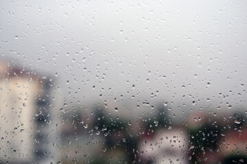 Raindrops falling on the balcony glass, raindrops sliding off the glass,