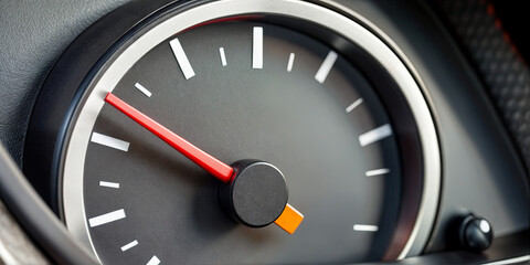 Naklejka premium A close-up view of a speedometer showing the vehicle's speed while in motion. The indicator is pointing towards a lower speed range, highlighting a calm drive on a sunny day