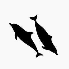 Fototapeta premium Silhouettes of two dolphins swimming in the water.