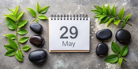 Calendar Date of May 29 with Notepad, Black Stones, and Green Leaves Capturing the Essence of Spring in a Rule of Thirds Composition