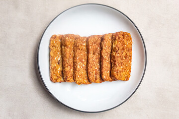 pieces of fried tempeh, made from soybeans, served on a plate.