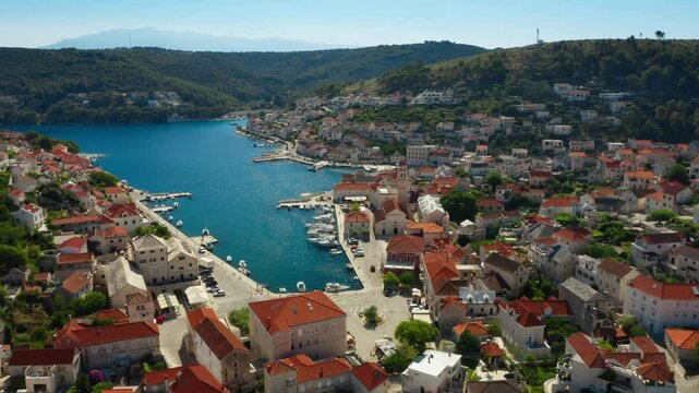 Town embankment and the mooring dock for boats, sailboats, and yachts in the port on the Adriatic coast. The harbor in the coastal town of Pucisca (Puči&scaron;ća) on the island of Brac (Brač), Croatia.