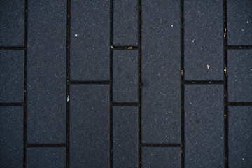 Dark gray stone tile pavement in rectangular grid