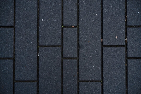 Dark gray stone tile pavement in rectangular grid