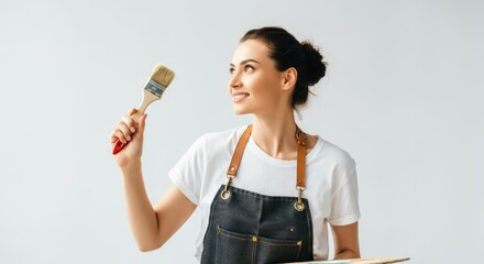 Young caucasian female artist smiling while holding paintbrush